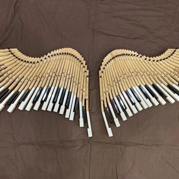 Angel Wings made from old piano keys on a hidden wooden base .